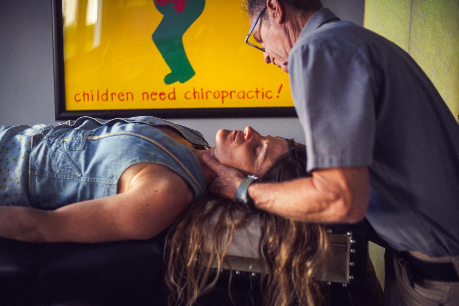 Dr. Joe DeMoss adjusting a patient's neck at DeMoss Chiropractic, Newport Beach